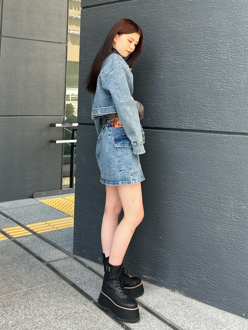 ブルー系のスカート、ブルー系のデニムジャケット、ブラック系のTシャツ/カットソーを着用したレディースの夏コーディネートの2枚目の写真