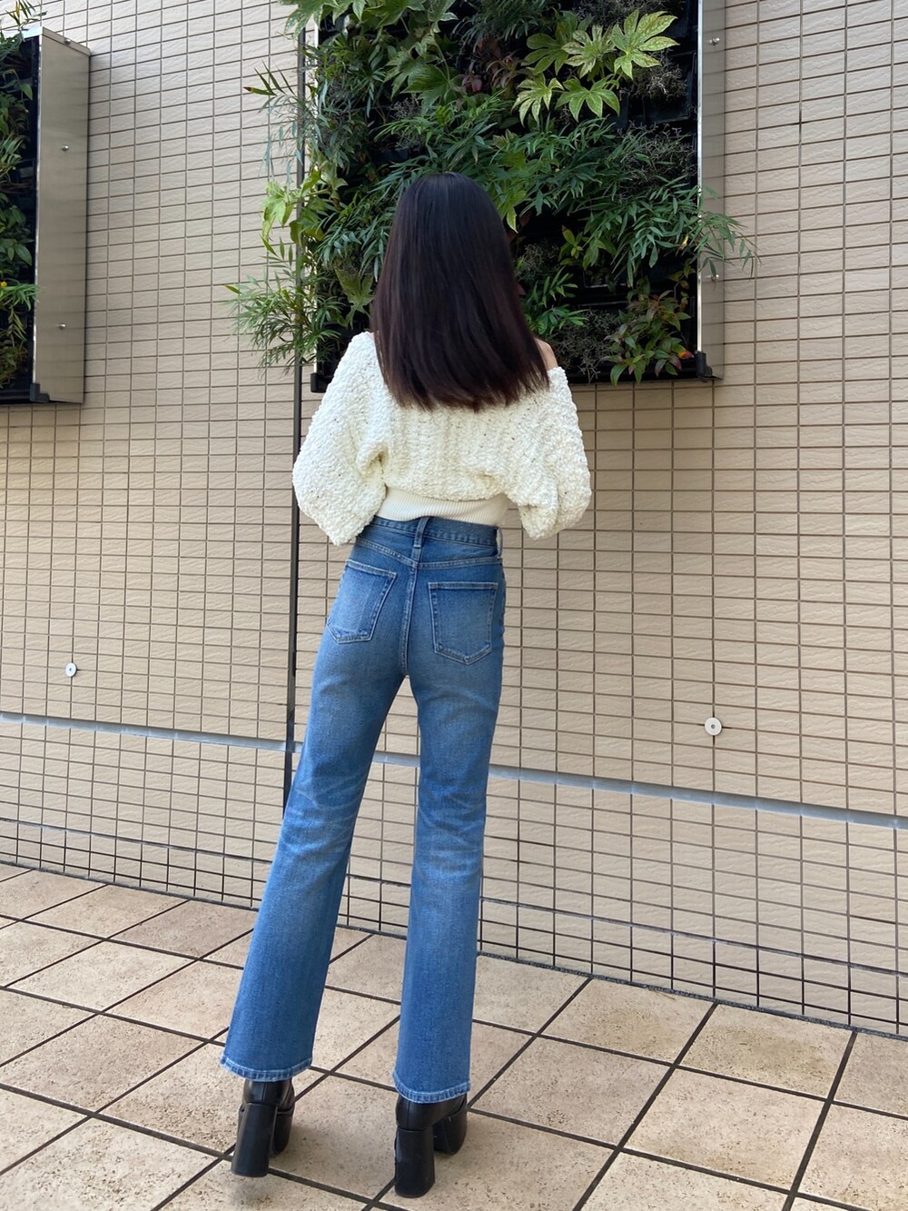 ブルー系のデニムパンツ、ホワイト系のニット/セーターを着用したレディースの秋コーディネートの4枚目の写真