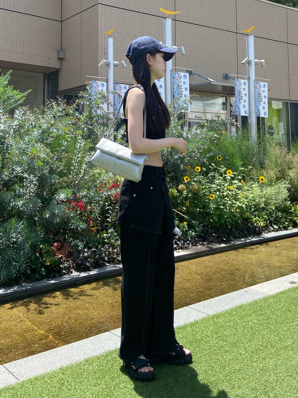 ブラック系のデニムパンツ、ブラック系のシャツ/ブラウス、ブルー系のキャップを着用したレディースの夏コーディネートの3枚目の写真