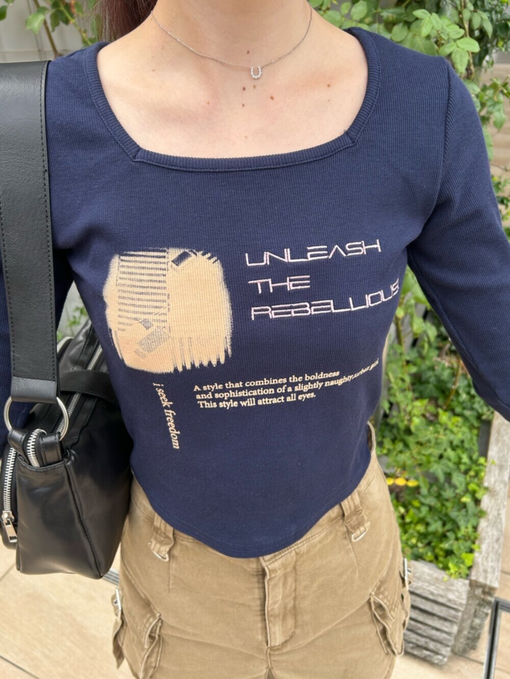 ブラック系のブーツ、ブルー系のTシャツ/カットソー、ベージュ系のスカートを着用したレディースの秋コーディネートの5枚目の写真