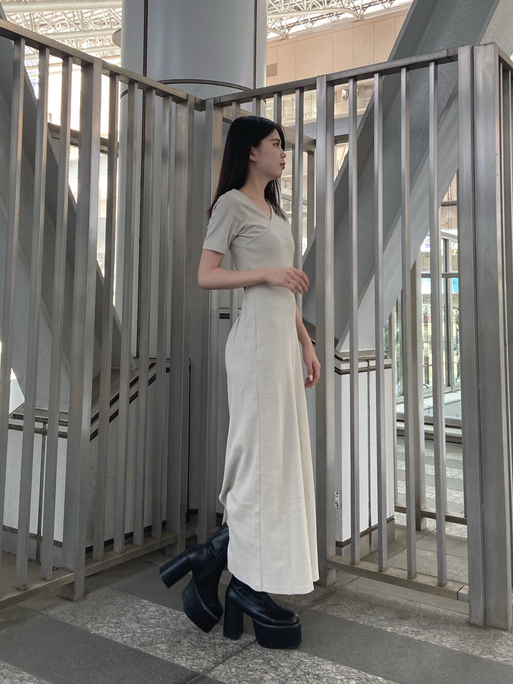 ホワイト系のワンピース、ブラック系のブーツを着用したレディースの夏コーディネートの2枚目の写真