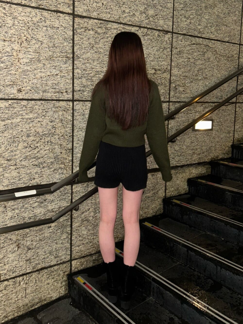 ブラック系のブーツ、グリーン系のニット/セーター、ブラック系のその他パンツを着用したレディースの冬コーディネートの2枚目の写真