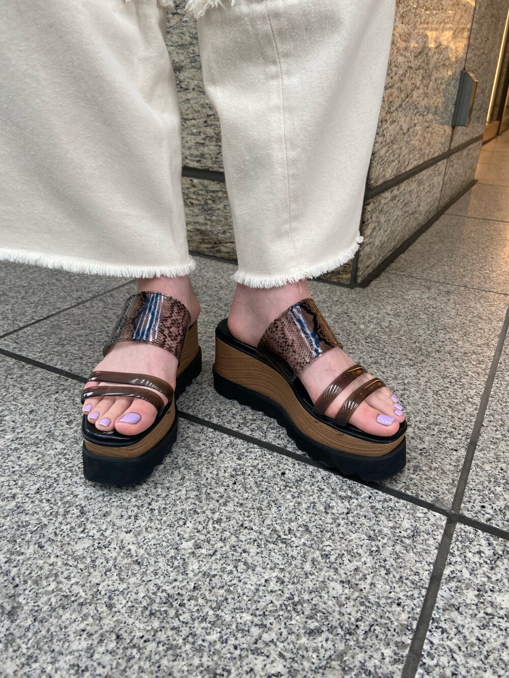 ブルー系のニット/セーター、ホワイト系のデニムパンツ、ブラック系のサンダルを着用したレディースの春コーディネートの8枚目の写真