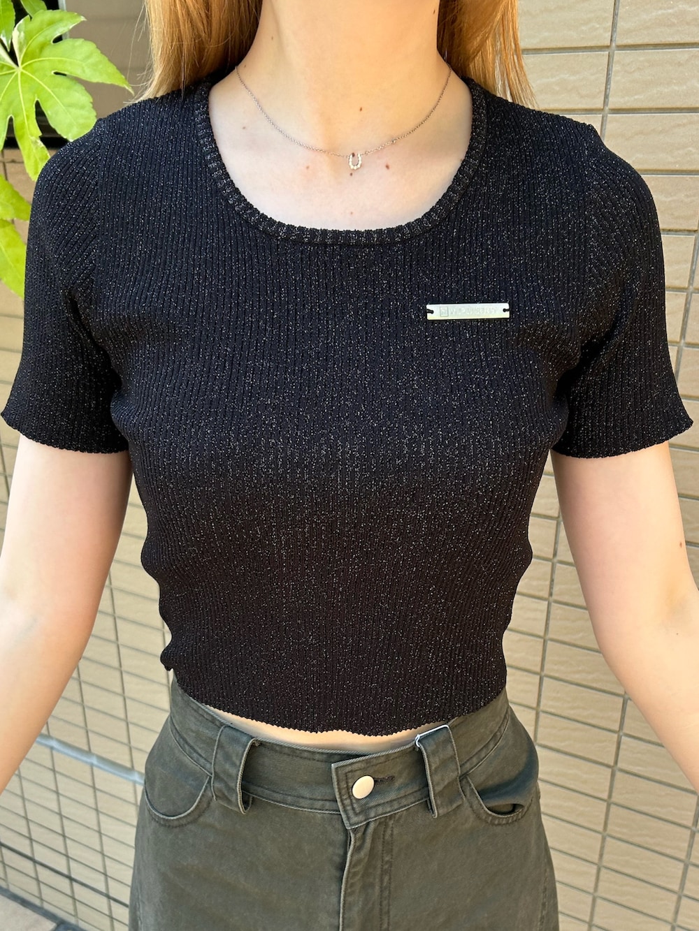 ブラック系のニット/セーター、グリーン系のその他パンツ、ブラック系のブーツを着用したレディースの夏コーディネートの5枚目の写真