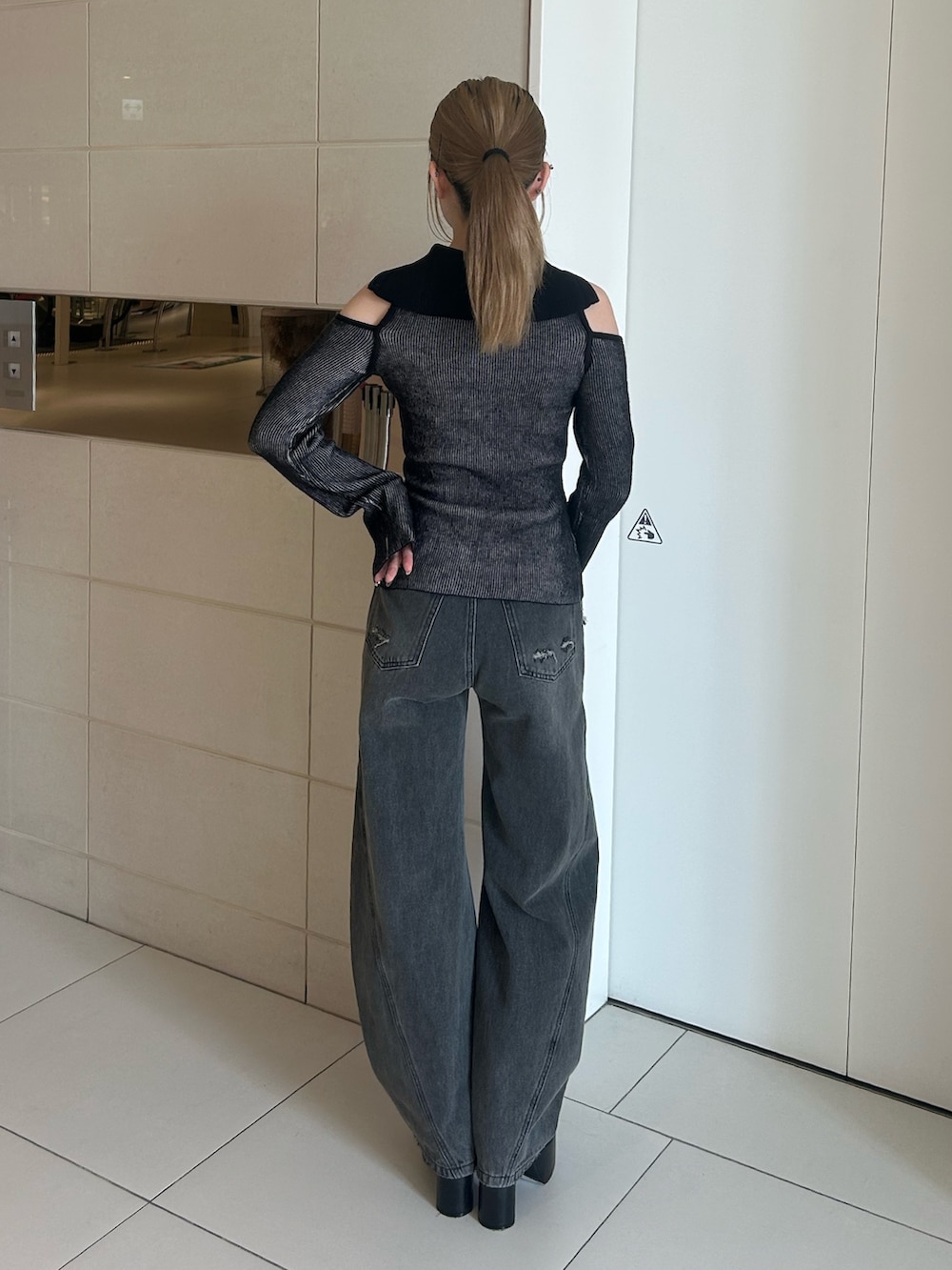 グレー系のデニムパンツ、その他のニット/セーター、ブラック系のブーツを着用したレディースの秋コーディネートの3枚目の写真