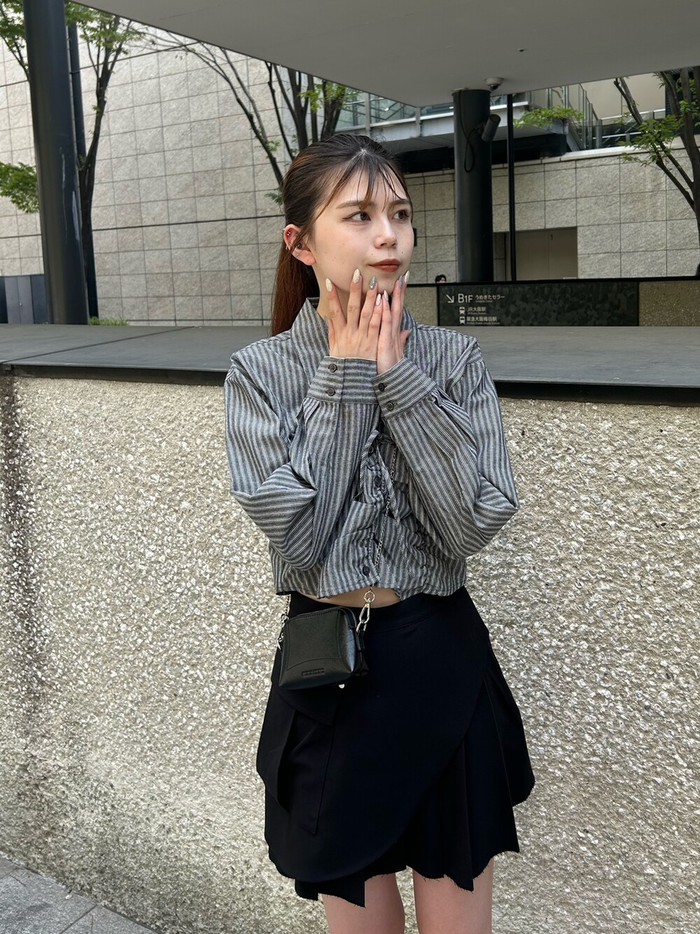 グレー系のシャツ/ブラウス、ブラック系のスカート、ブラック系のブーツを着用したレディースの夏コーディネートの4枚目の写真