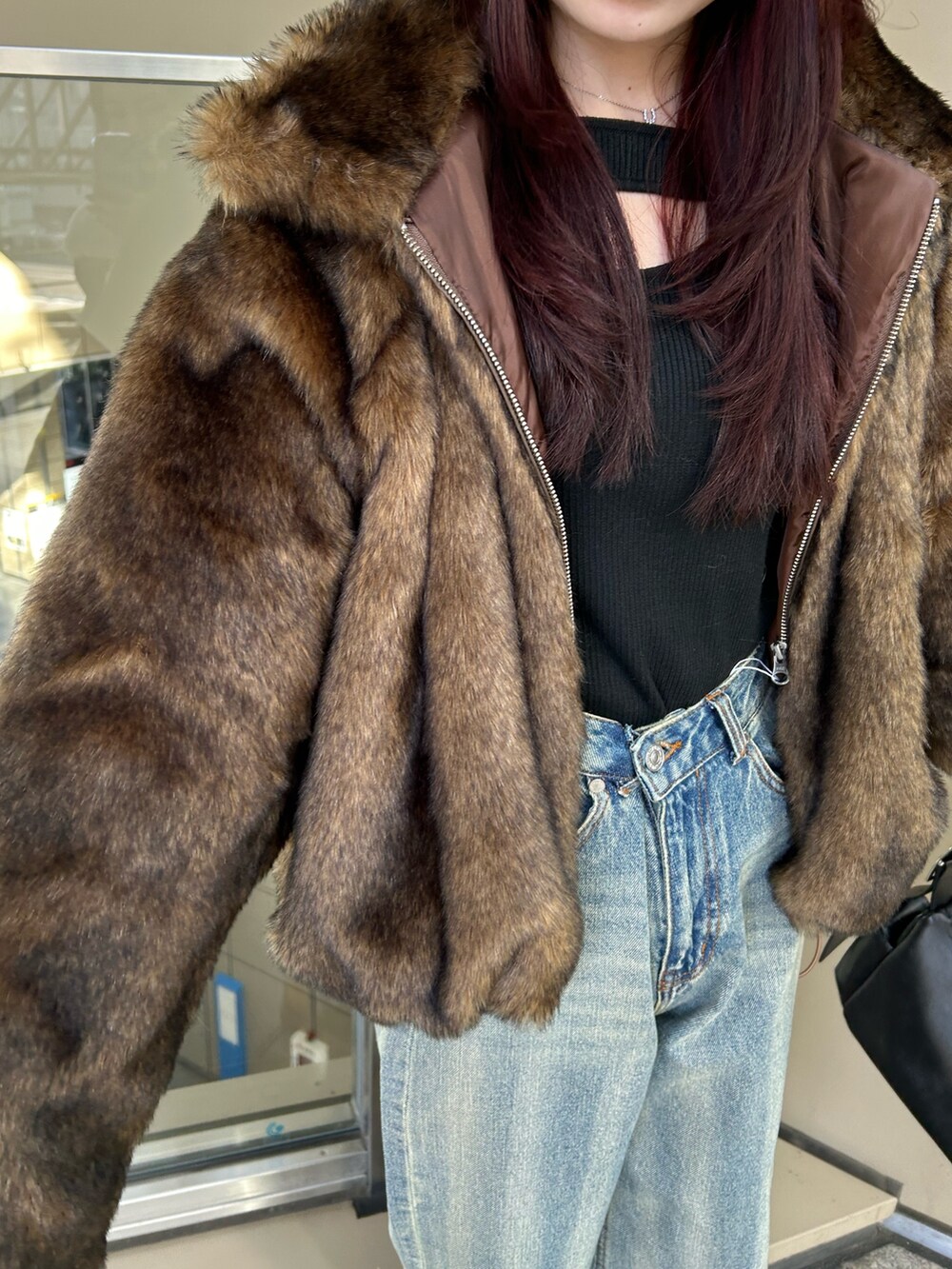 ブルー系のデニムパンツ、ブラウン系のブルゾン、ブラック系のニット/セーターを着用したレディースの冬コーディネートの6枚目の写真
