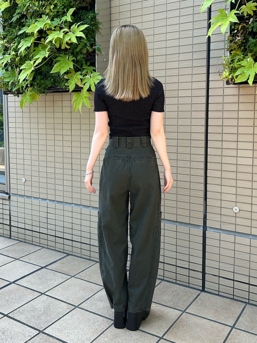 ブラック系のニット/セーター、グリーン系のその他パンツ、ブラック系のブーツを着用したレディースの夏コーディネートの3枚目の写真