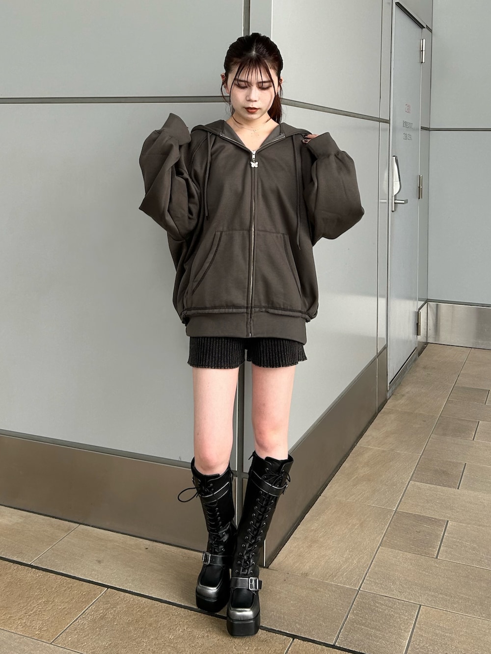 グレー系のパーカー、ブラック系のその他パンツ、ブラック系のブーツを着用したレディースの秋コーディネートの2枚目の写真