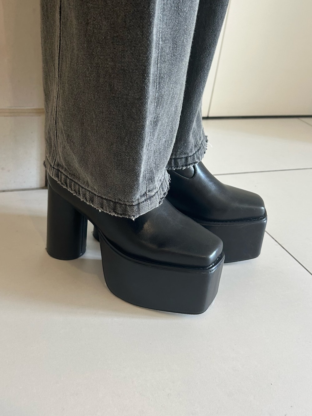 グレー系のデニムパンツ、その他のニット/セーター、ブラック系のブーツを着用したレディースの秋コーディネートの7枚目の写真