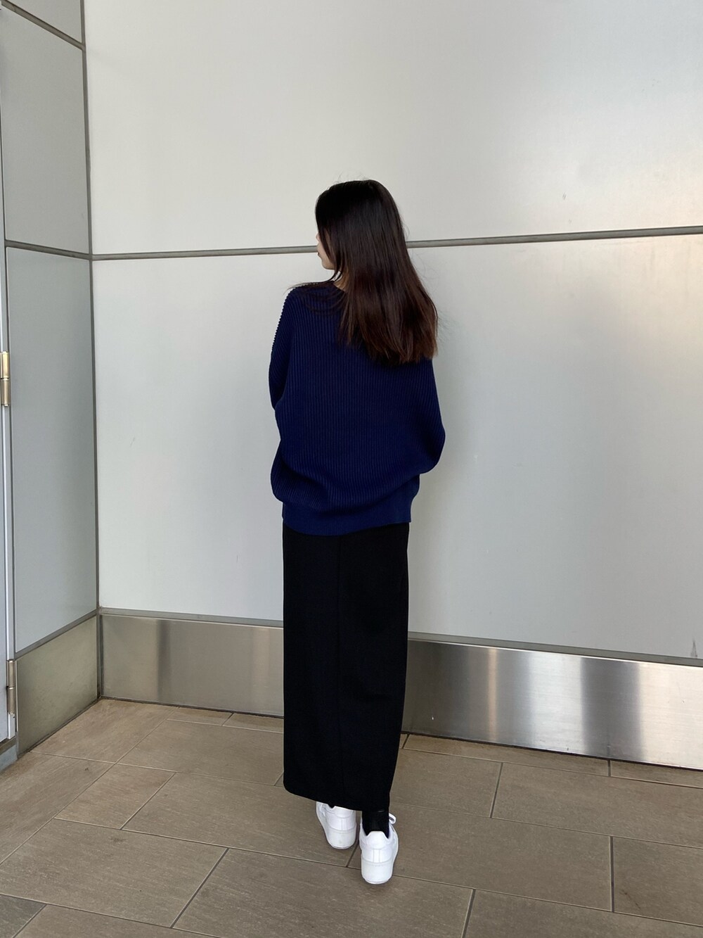 ブルー系のニット/セーター、ブラック系のスカートを着用したレディースの冬コーディネートの2枚目の写真