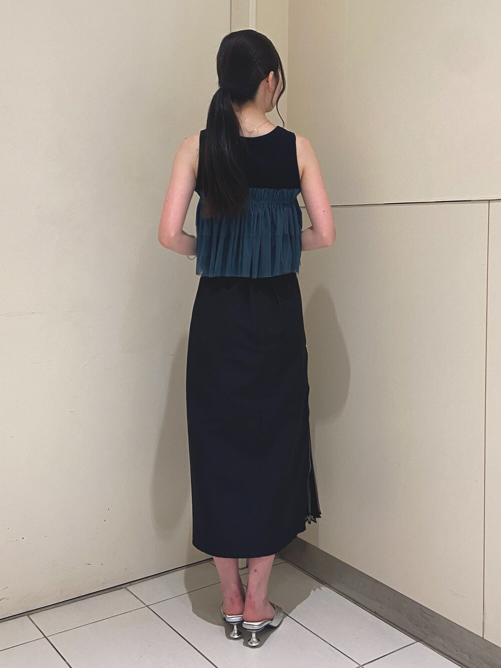 ブラック系のスカート、ブラック系のTシャツ/カットソー、シルバー系のサンダルを着用したレディースの夏コーディネートの3枚目の写真