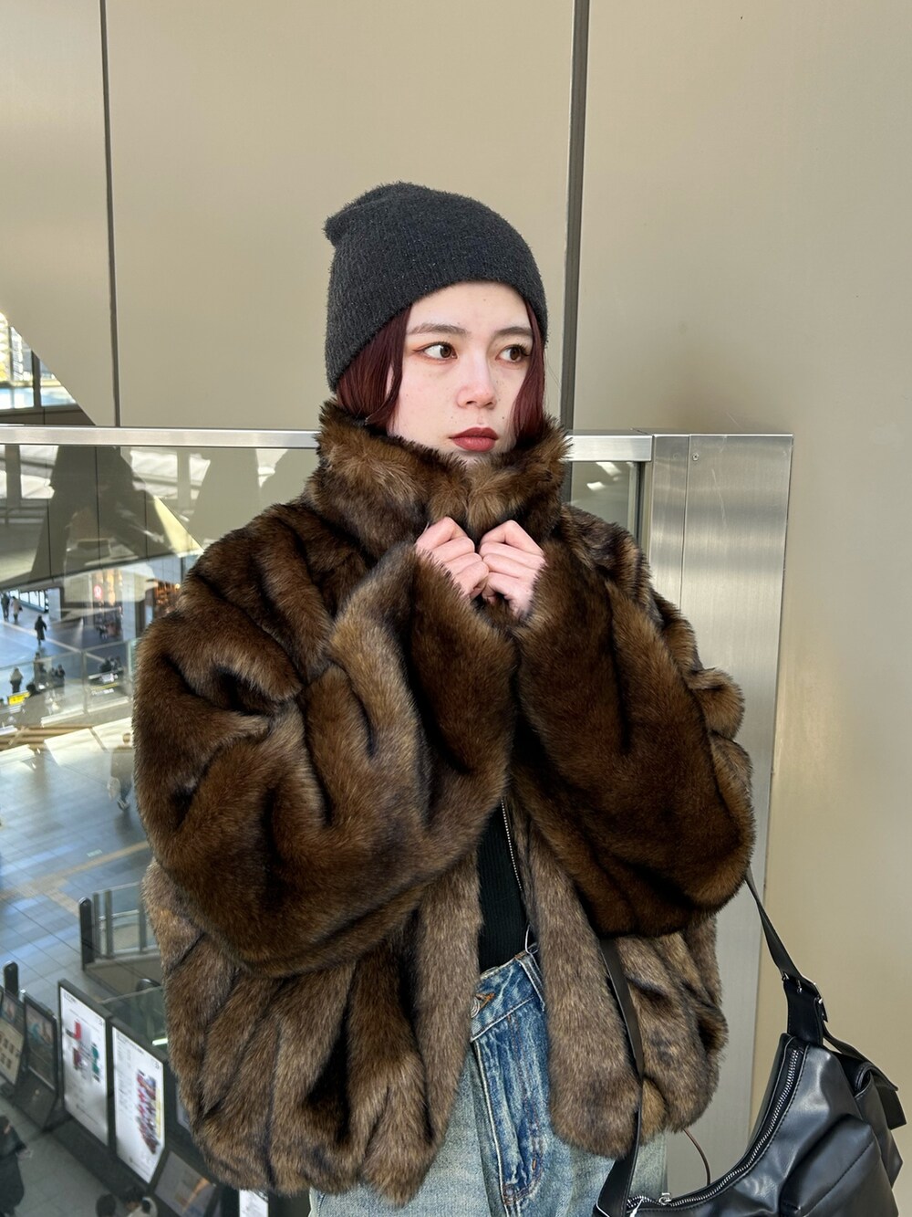 ブルー系のデニムパンツ、ブラウン系のブルゾン、ブラック系のニット/セーターを着用したレディースの冬コーディネートの5枚目の写真