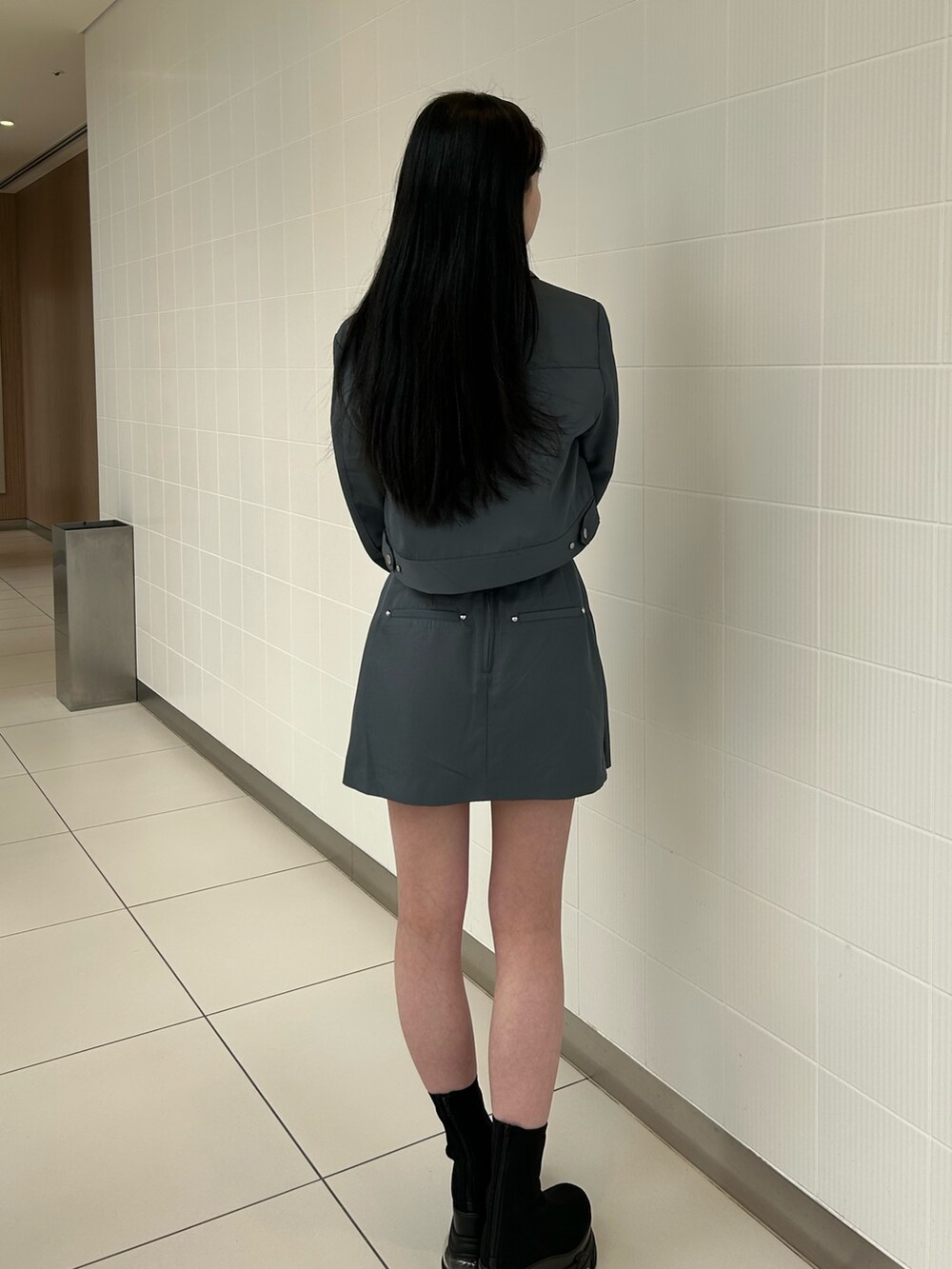 グレー系のスカート、グレー系のブルゾン、ホワイト系のTシャツ/カットソーを着用したレディースの春コーディネートの3枚目の写真