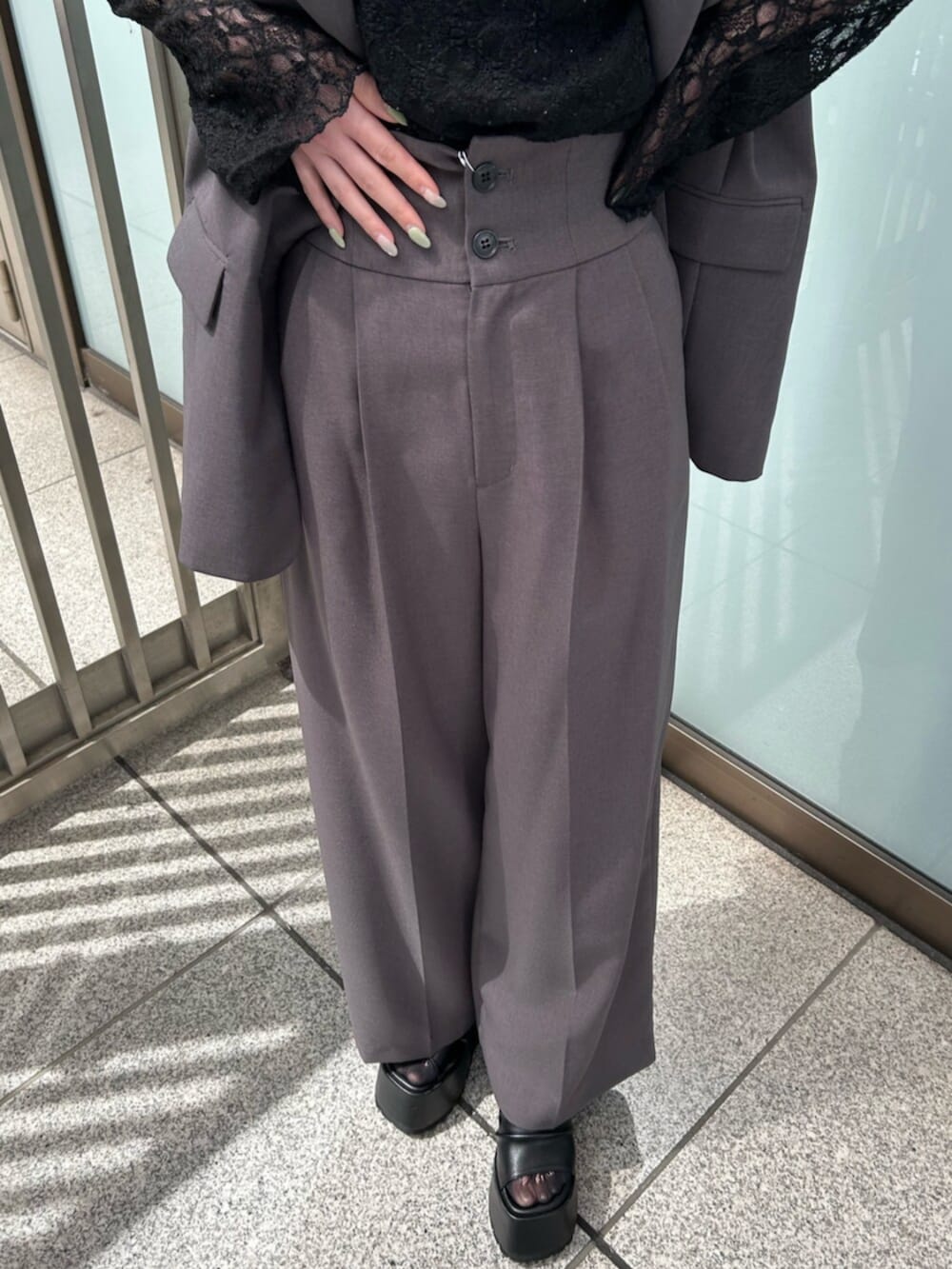 グレー系のベスト、グレー系のスラックス、ブラック系のTシャツ/カットソーを着用したレディースの春コーディネートの5枚目の写真