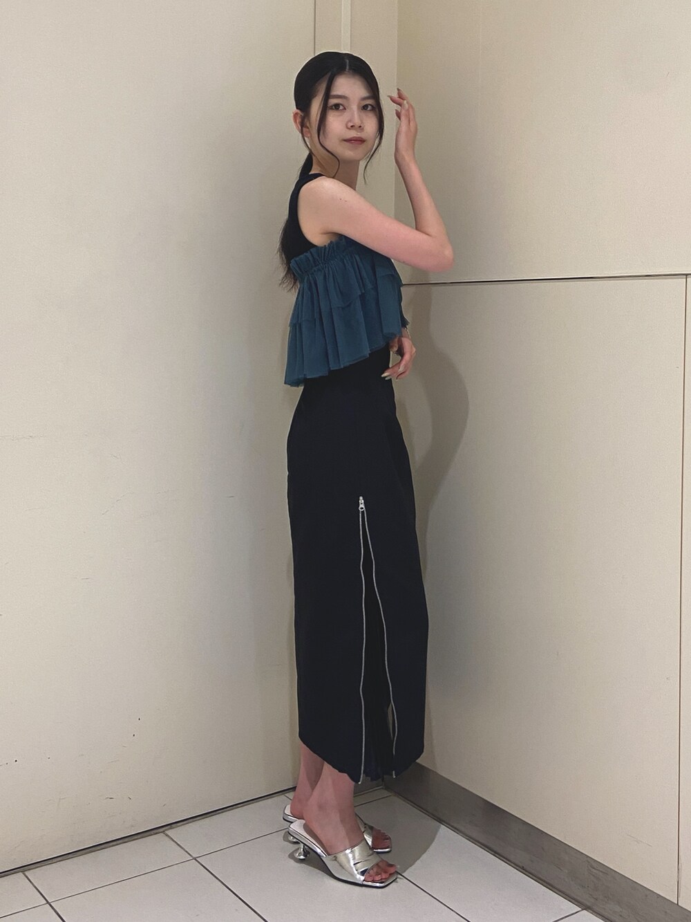 ブラック系のスカート、ブラック系のTシャツ/カットソー、シルバー系のサンダルを着用したレディースの夏コーディネートの2枚目の写真