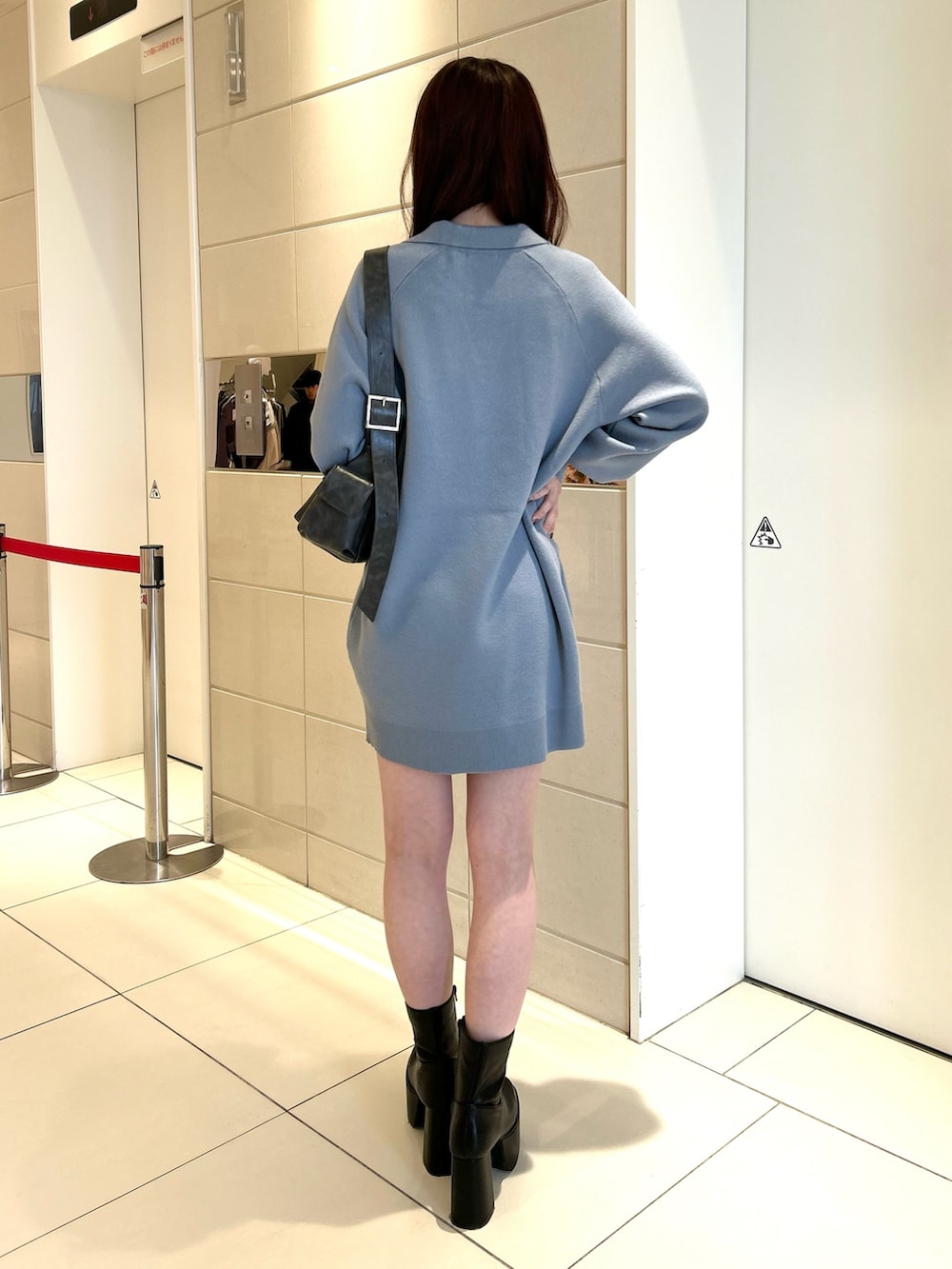 ブルー系のワンピース、ブラック系のブーツを着用したレディースの冬コーディネートの3枚目の写真