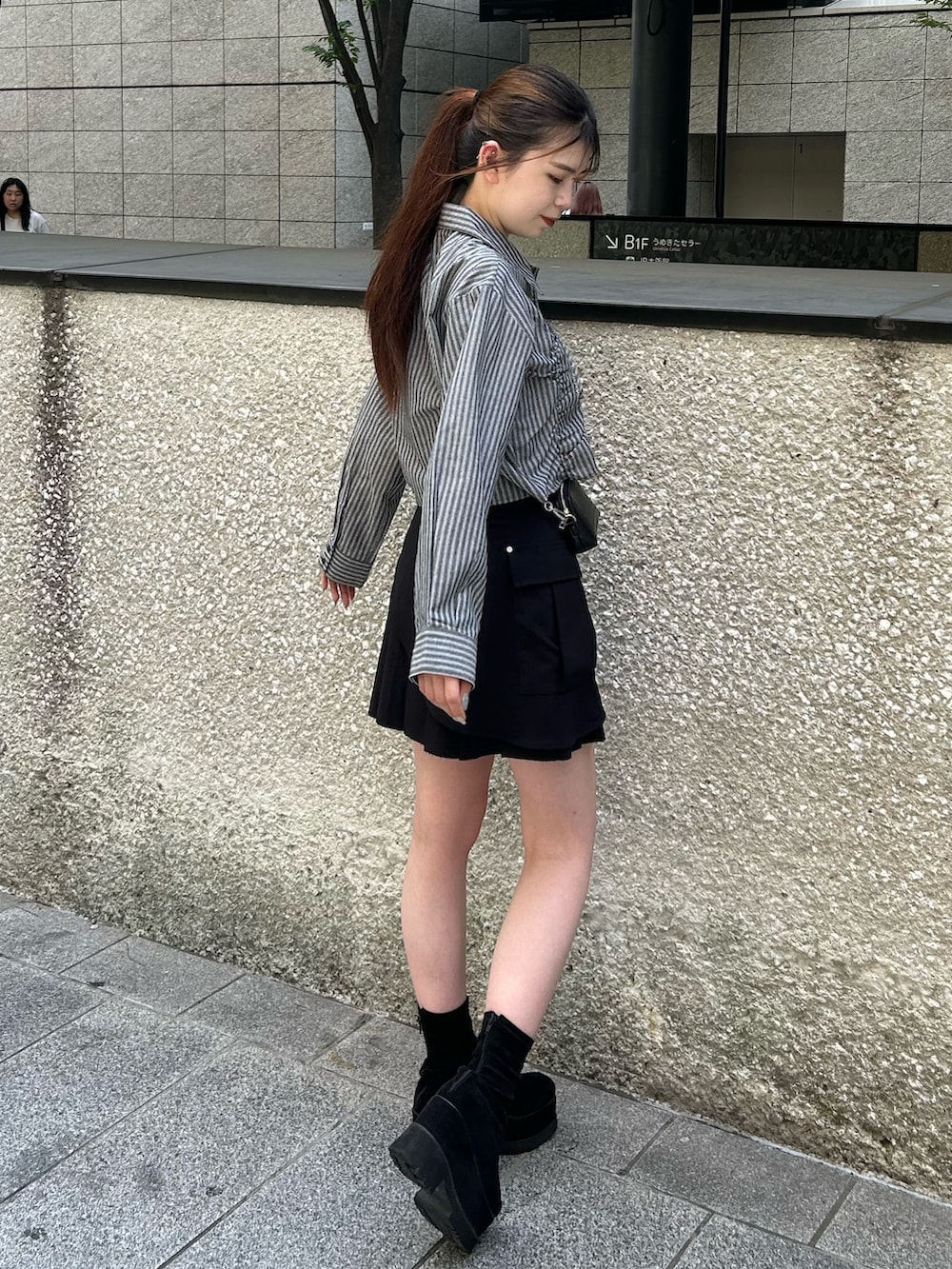 グレー系のシャツ/ブラウス、ブラック系のスカート、ブラック系のブーツを着用したレディースの夏コーディネートの2枚目の写真