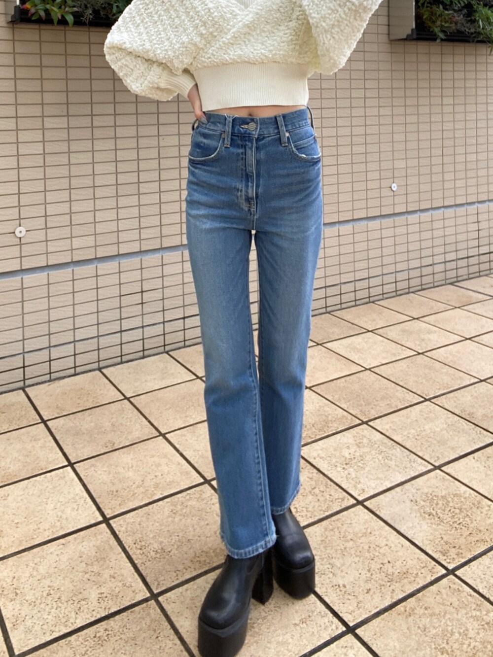 ブルー系のデニムパンツ、ホワイト系のニット/セーターを着用したレディースの秋コーディネートの6枚目の写真