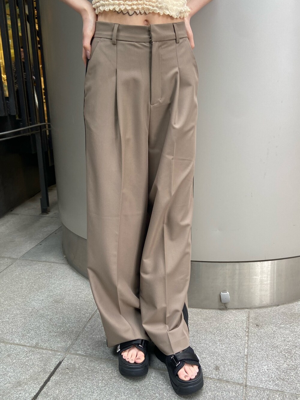 ブラウン系のその他パンツ、ホワイト系のシャツ/ブラウス、ブラック系のサンダルを着用したレディースの春コーディネートの6枚目の写真