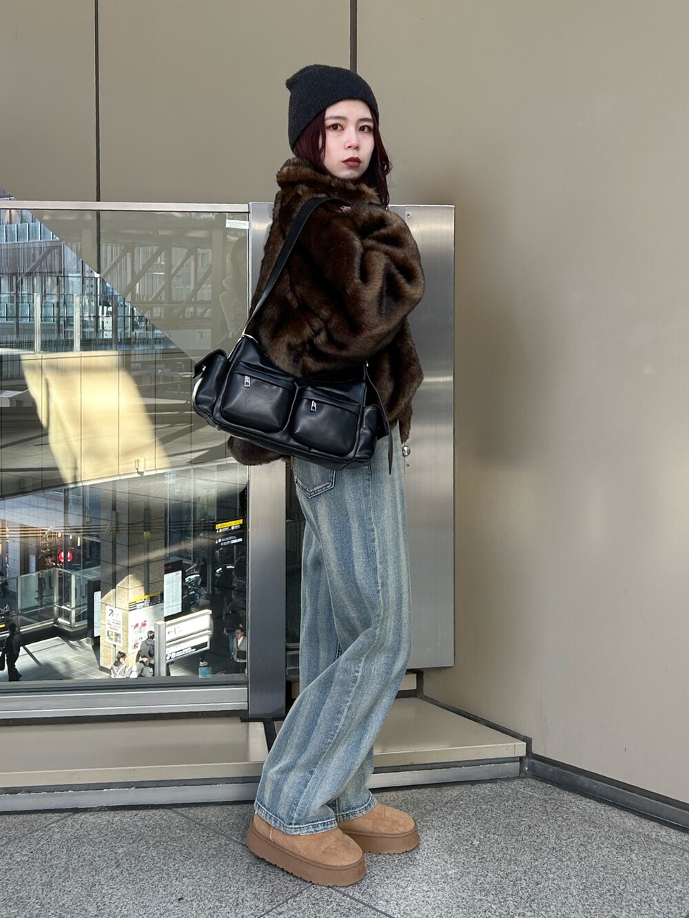 ブルー系のデニムパンツ、ブラウン系のブルゾン、ブラック系のニット/セーターを着用したレディースの冬コーディネートの2枚目の写真
