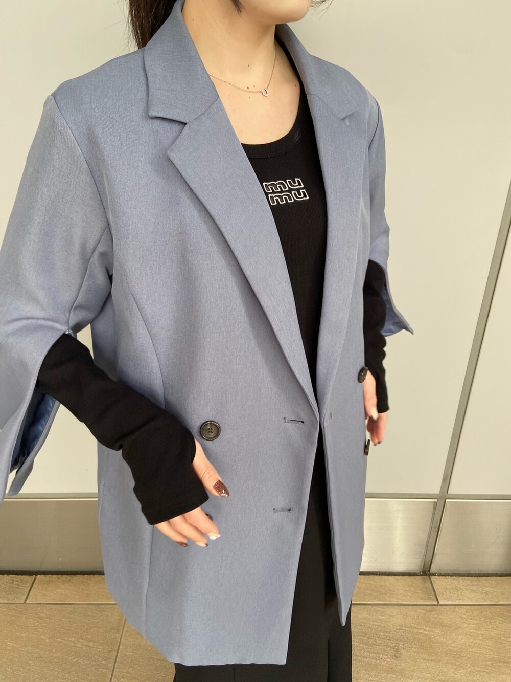 ブルー系のテーラードジャケット、ブラック系のTシャツ/カットソー、ブラック系のスカートを着用したレディースの冬コーディネートの4枚目の写真