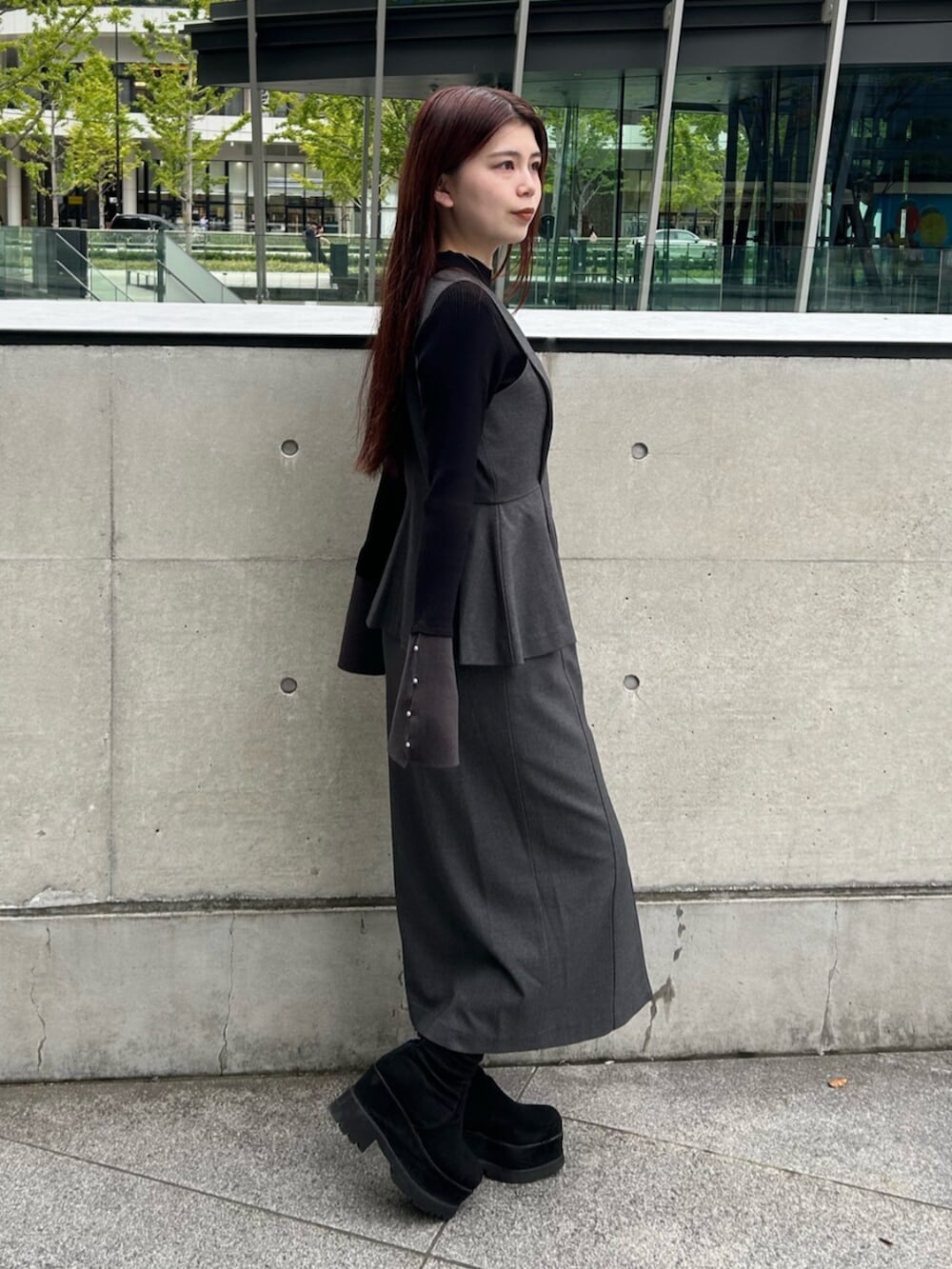 ブラック系のブーツ、グレー系のジャンパースカート、ブラック系のニット/セーターを着用したレディースの秋コーディネートの3枚目の写真