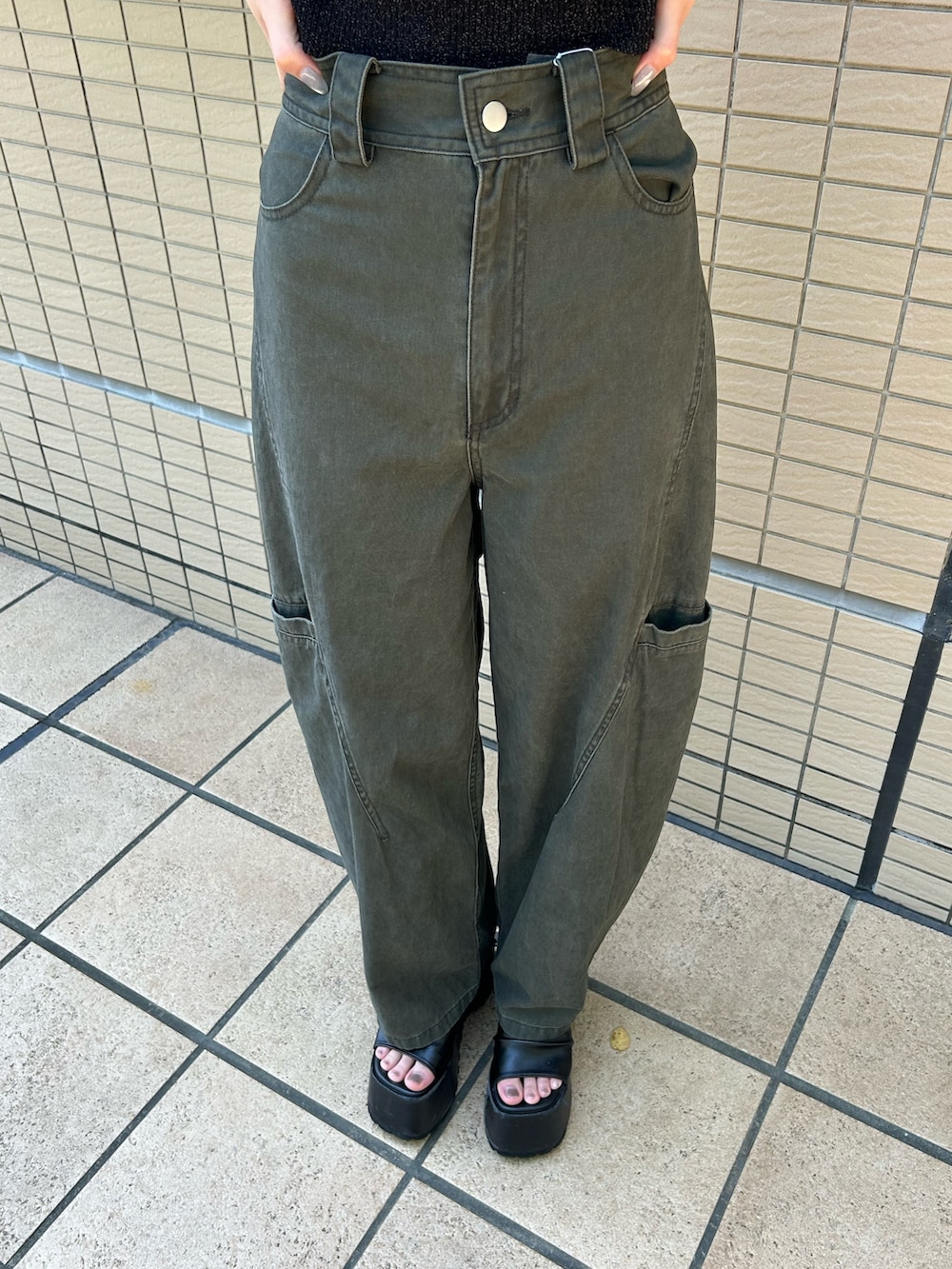 ブラック系のニット/セーター、グリーン系のその他パンツ、ブラック系のブーツを着用したレディースの夏コーディネートの6枚目の写真