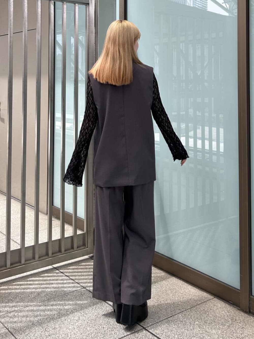 グレー系のベスト、グレー系のスラックス、ブラック系のTシャツ/カットソーを着用したレディースの春コーディネートの3枚目の写真