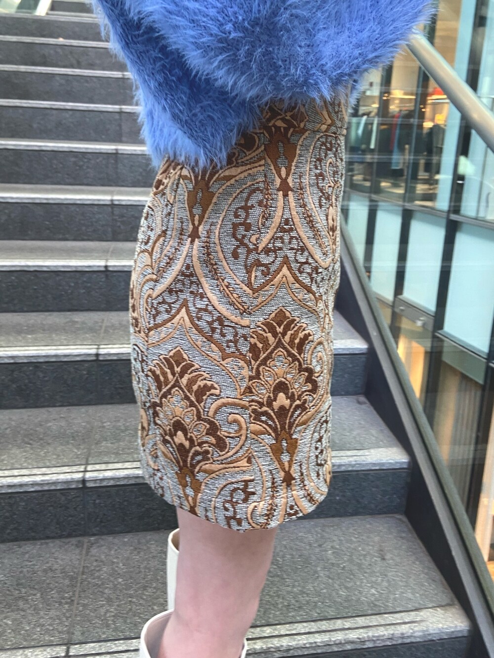 ブルー系のスカート、ブルー系のニット/セーター、ホワイト系のブーツを着用したレディースの秋コーディネートの7枚目の写真