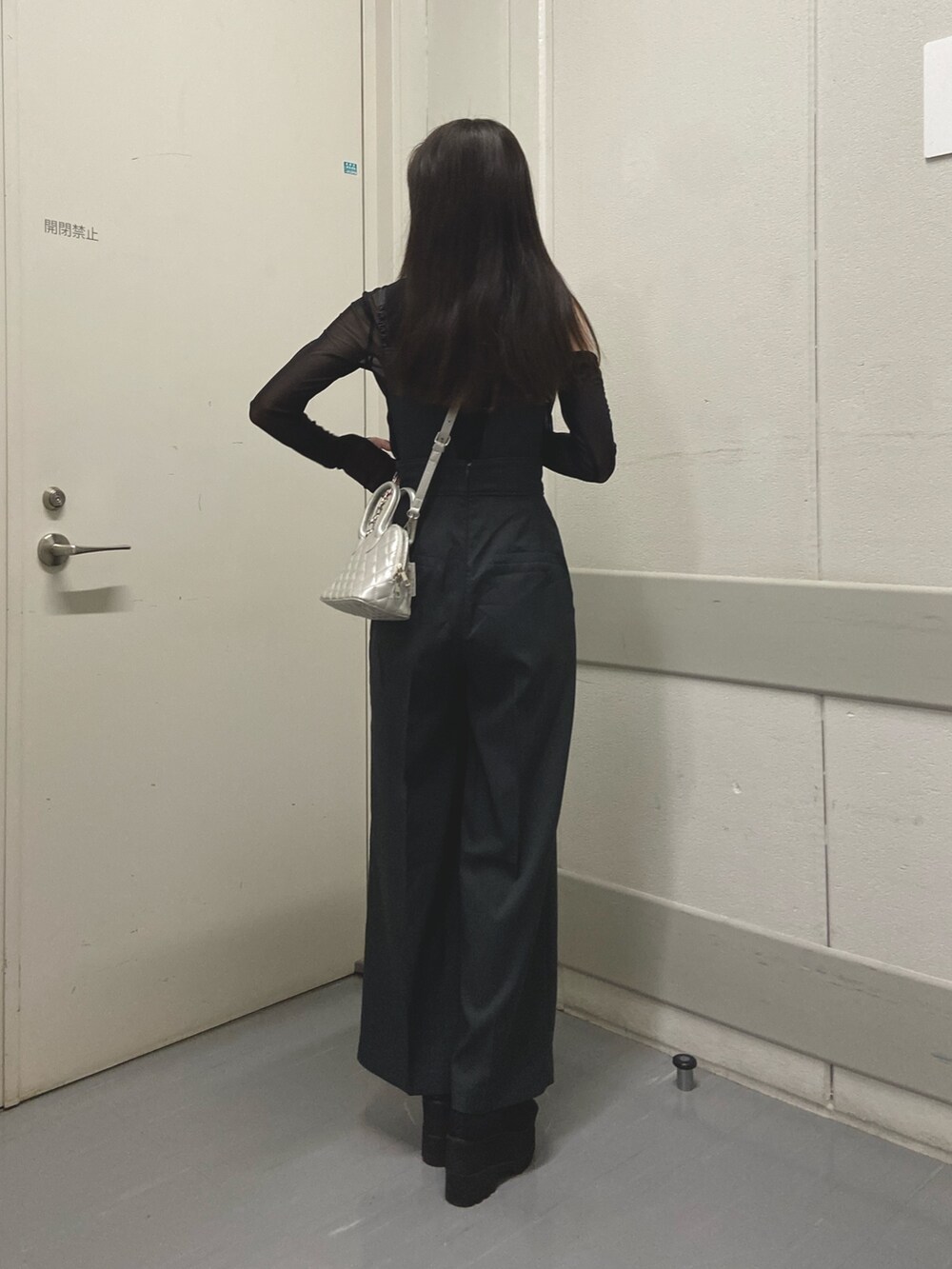 グレー系のワンピース、ブラック系のTシャツ/カットソー、ブラック系のブーツを着用したレディースの春コーディネートの3枚目の写真