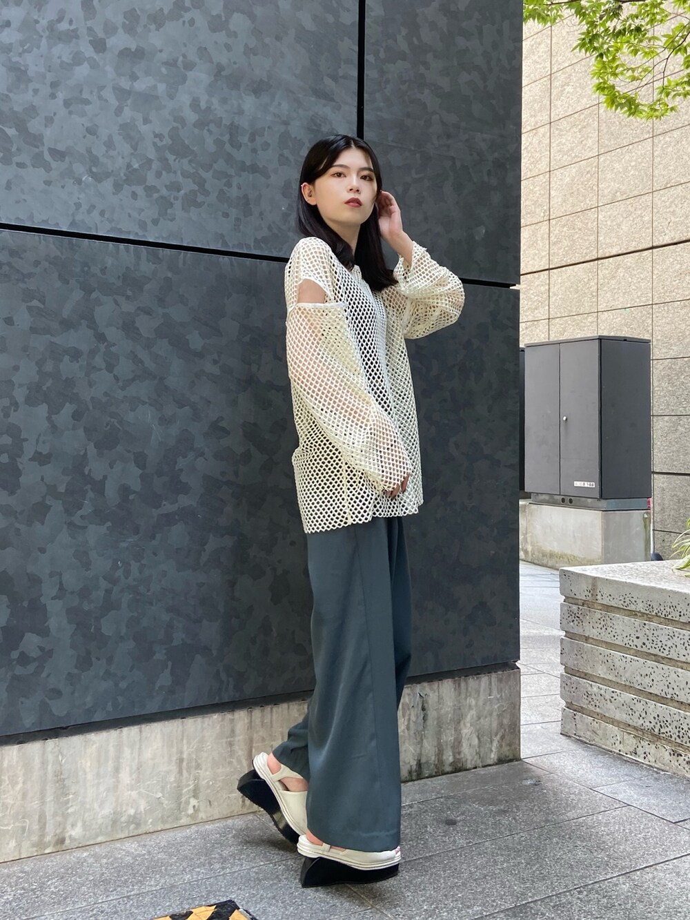 ホワイト系のシャツ/ブラウス、ブルー系のスラックス、ホワイト系のサンダルを着用したレディースの夏コーディネートの2枚目の写真