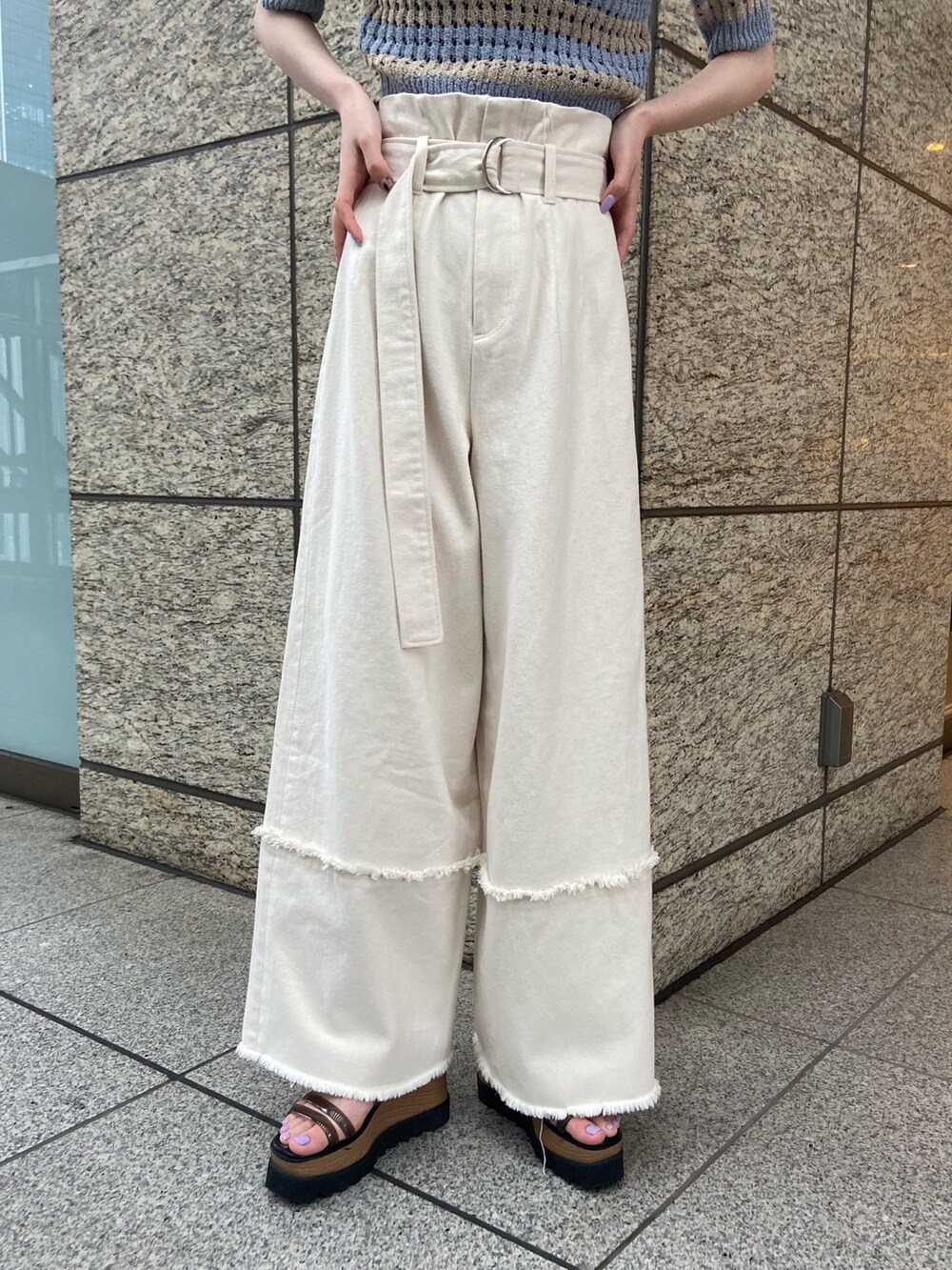 ブルー系のニット/セーター、ホワイト系のデニムパンツ、ブラック系のサンダルを着用したレディースの春コーディネートの6枚目の写真