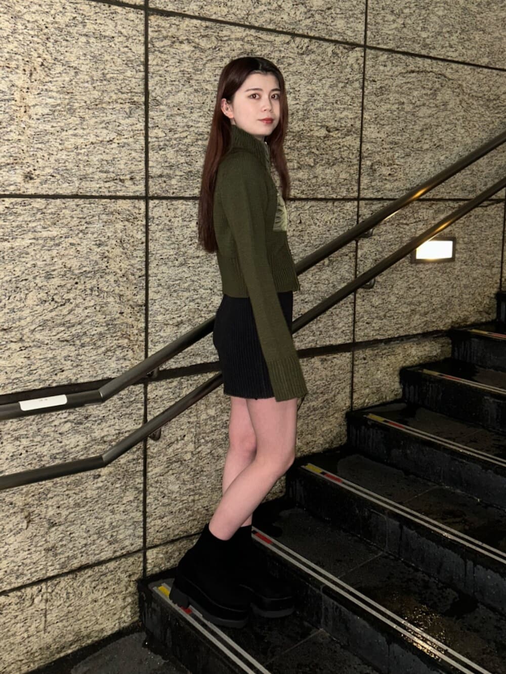 ブラック系のブーツ、グリーン系のニット/セーター、ブラック系のその他パンツを着用したレディースの冬コーディネートの3枚目の写真