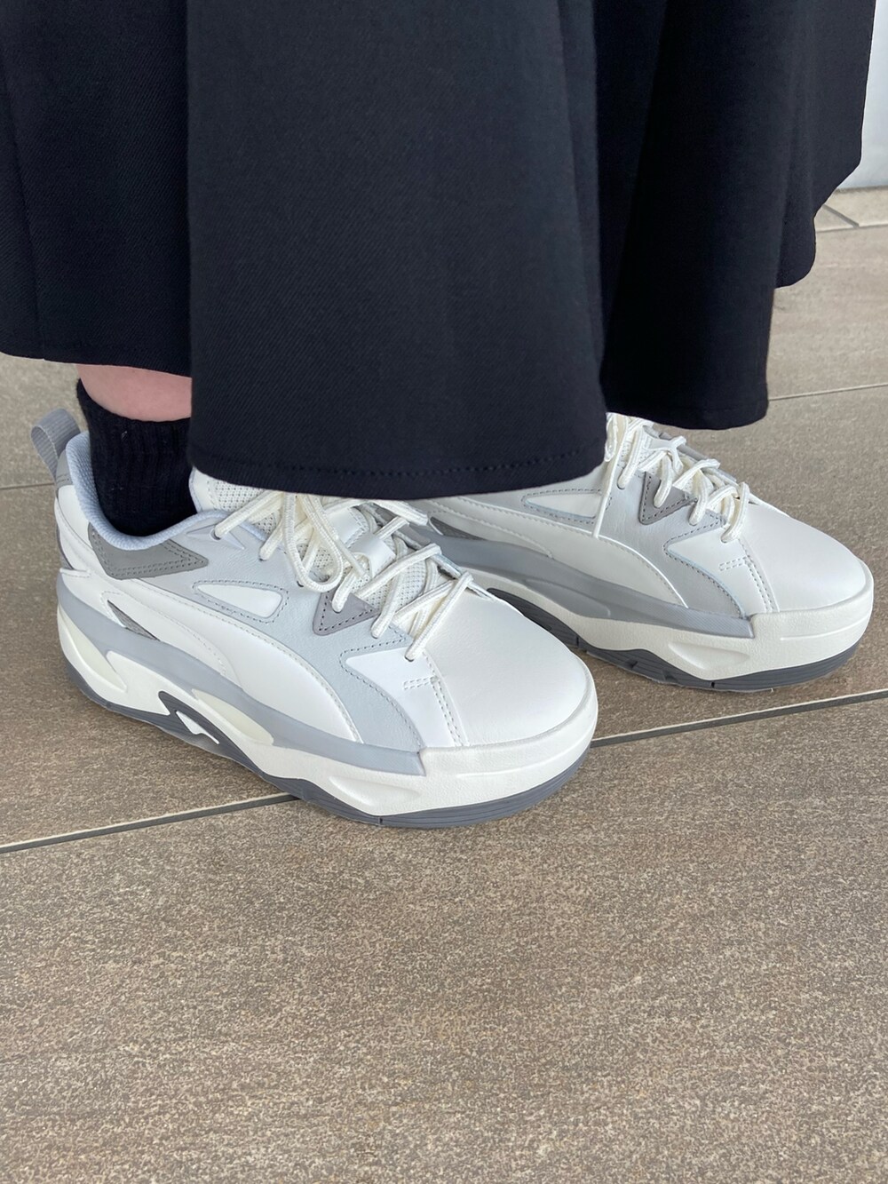 ブルー系のテーラードジャケット、ブラック系のTシャツ/カットソー、ブラック系のスカートを着用したレディースの冬コーディネートの6枚目の写真