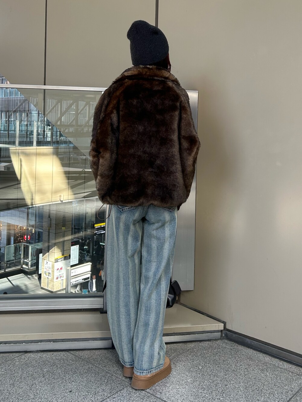 ブルー系のデニムパンツ、ブラウン系のブルゾン、ブラック系のニット/セーターを着用したレディースの冬コーディネートの3枚目の写真