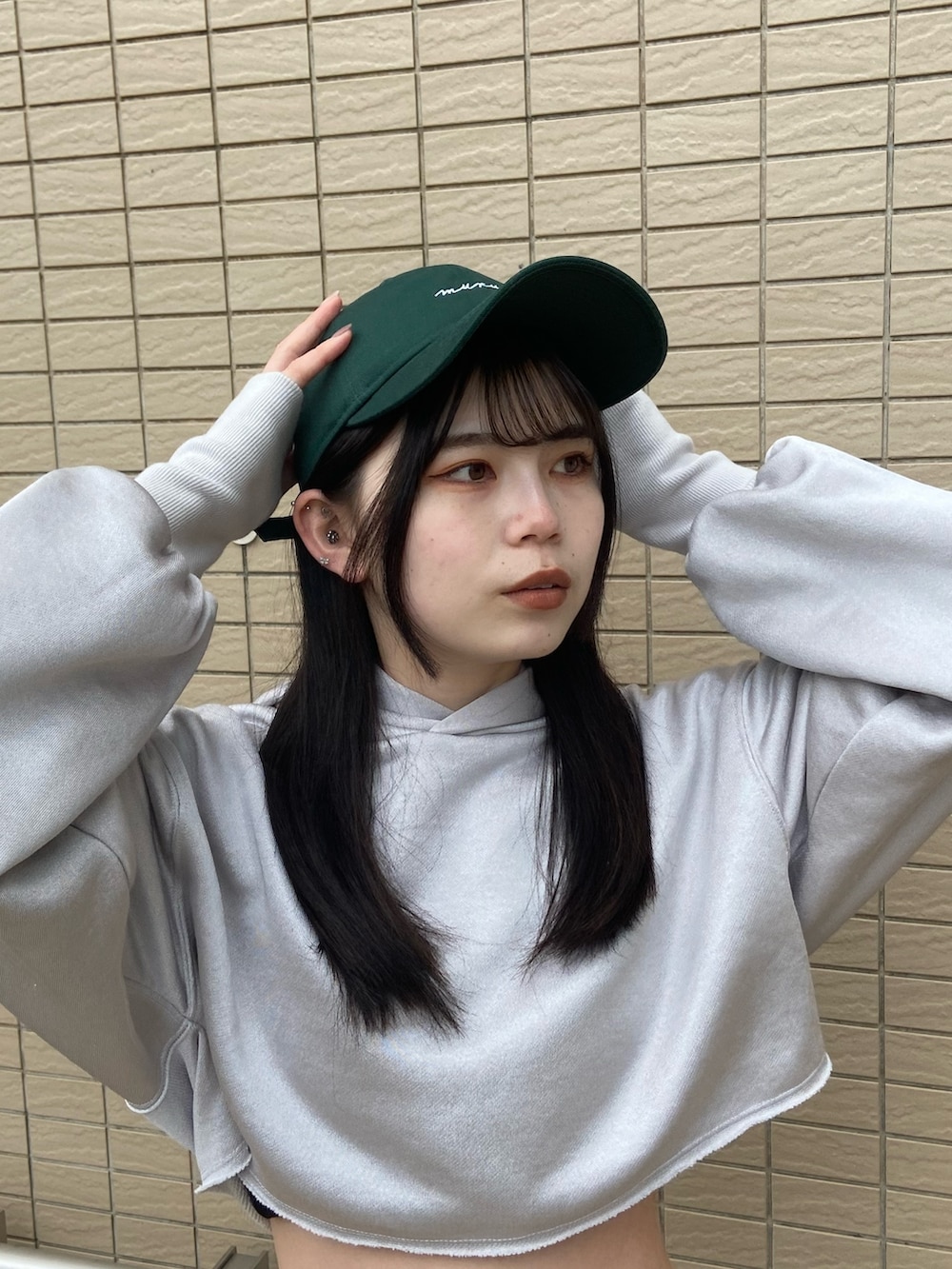 グレー系のカーゴパンツ、グレー系のTシャツ/カットソー、グリーン系のキャップを着用したレディースの冬コーディネートの4枚目の写真