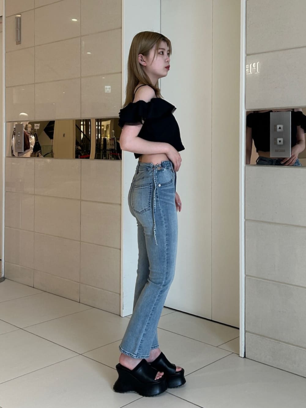 ブルー系のデニムパンツ、ブラック系のシャツ/ブラウス、ブラック系のサンダルを着用したレディースの夏コーディネートの2枚目の写真
