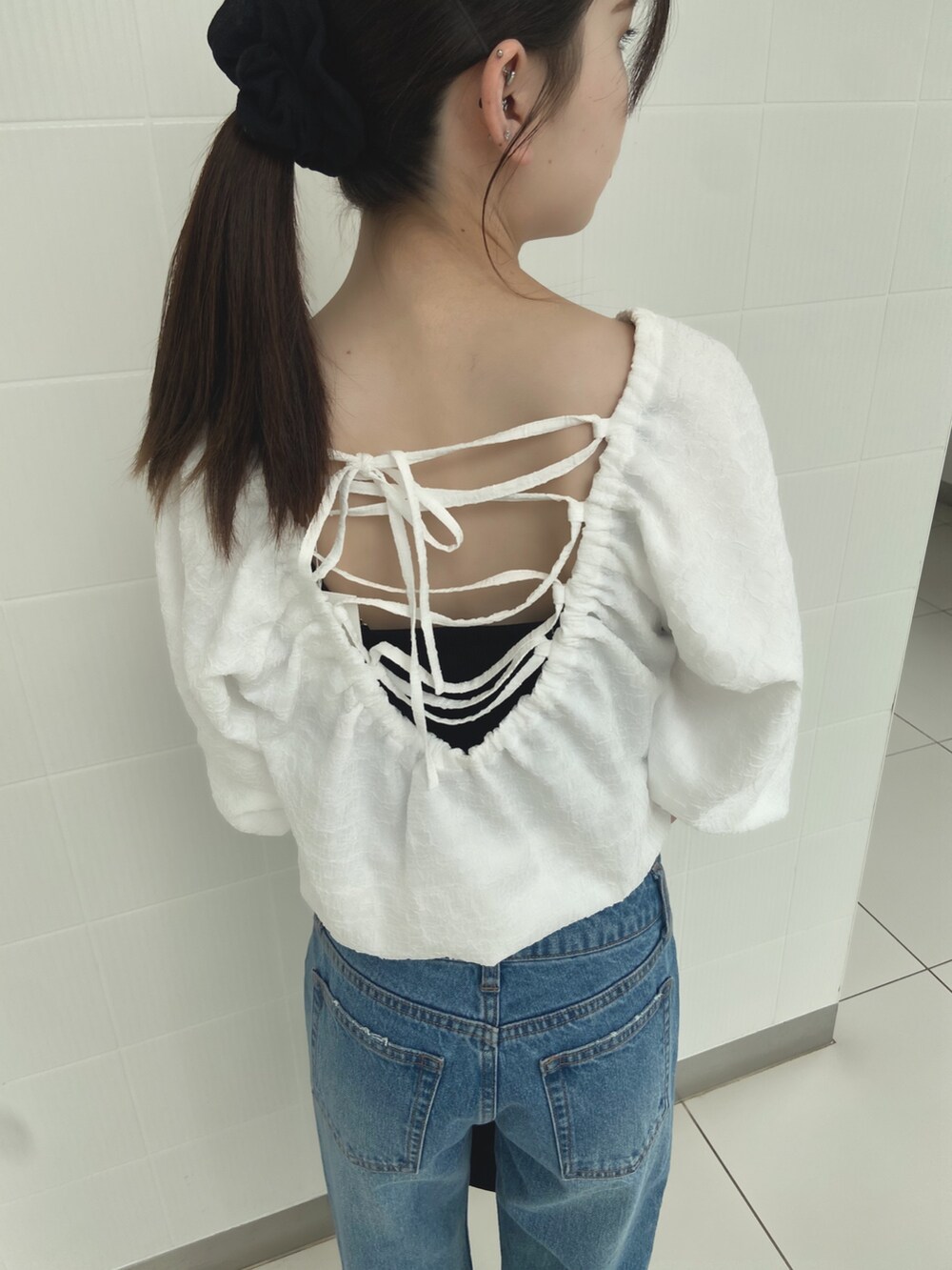 ホワイト系のシャツ/ブラウス、ブルー系のデニムパンツ、ブラック系のサンダルを着用したレディースの夏コーディネートの6枚目の写真