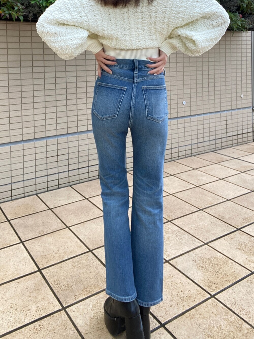 ブルー系のデニムパンツ、ホワイト系のニット/セーターを着用したレディースの秋コーディネートの8枚目の写真