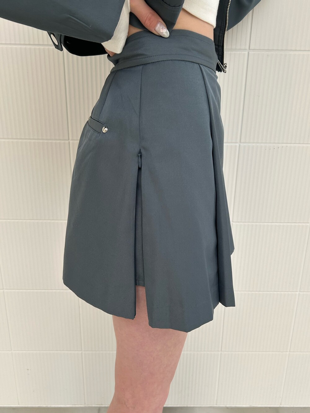 グレー系のスカート、グレー系のブルゾン、ホワイト系のTシャツ/カットソーを着用したレディースの春コーディネートの8枚目の写真