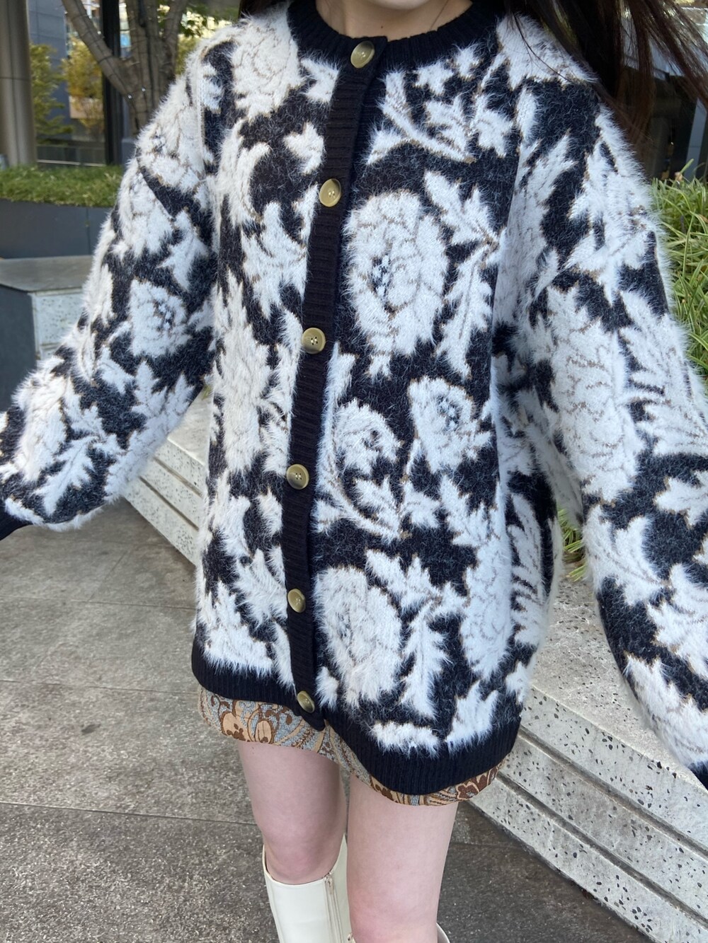 ブラック系のカーディガン/ボレロ、ホワイト系のブーツを着用したレディースの秋コーディネートの3枚目の写真