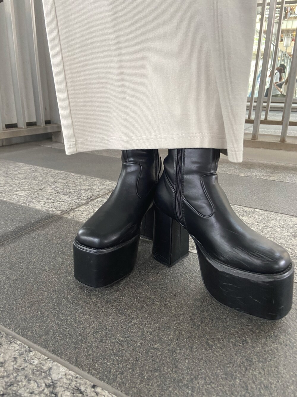 ホワイト系のワンピース、ブラック系のブーツを着用したレディースの夏コーディネートの6枚目の写真