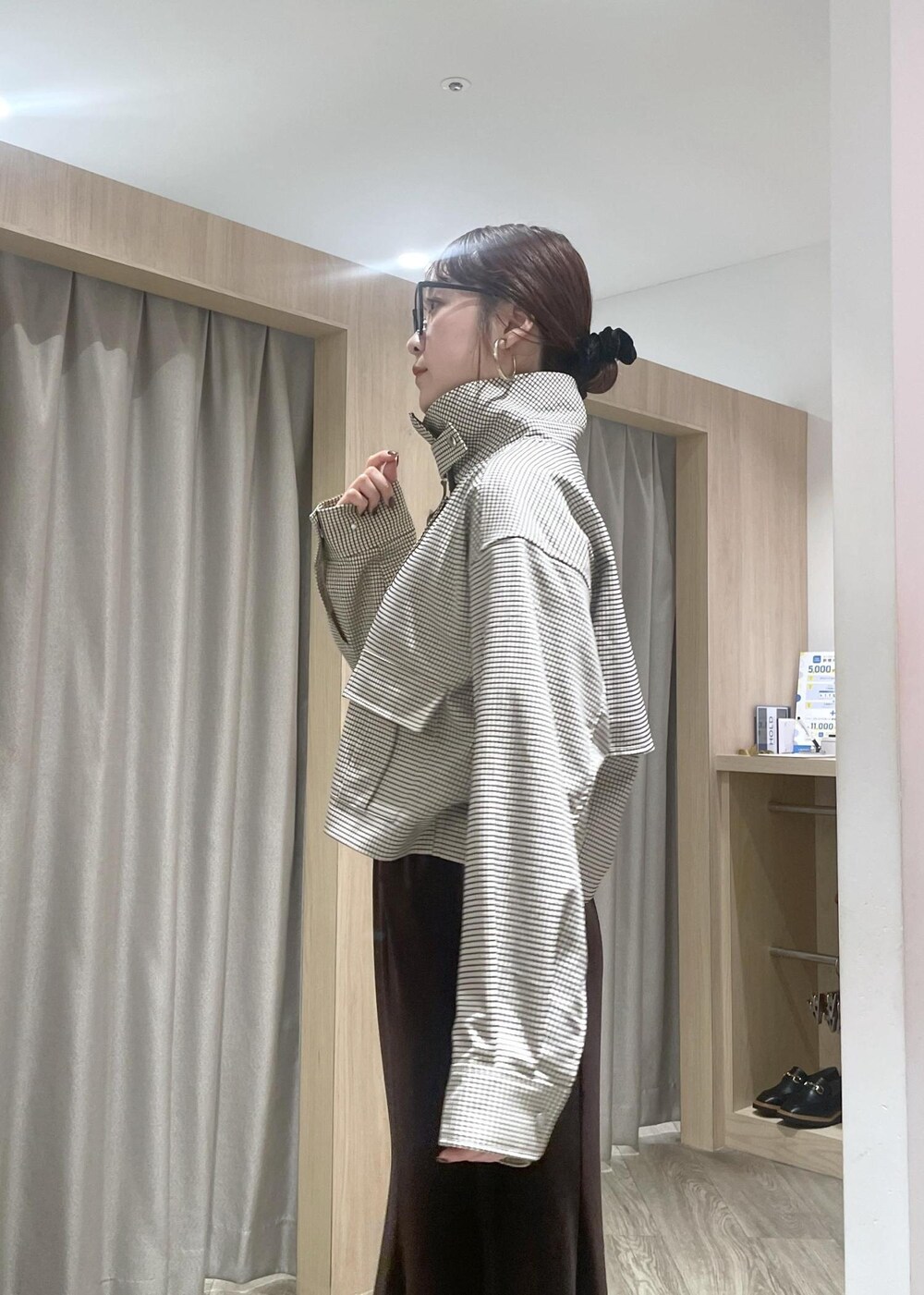 ブラック系のショルダーバッグ、ブラック系のブーツ、ベージュ系のカバーオールを着用したレディースの秋コーディネートの9枚目の写真