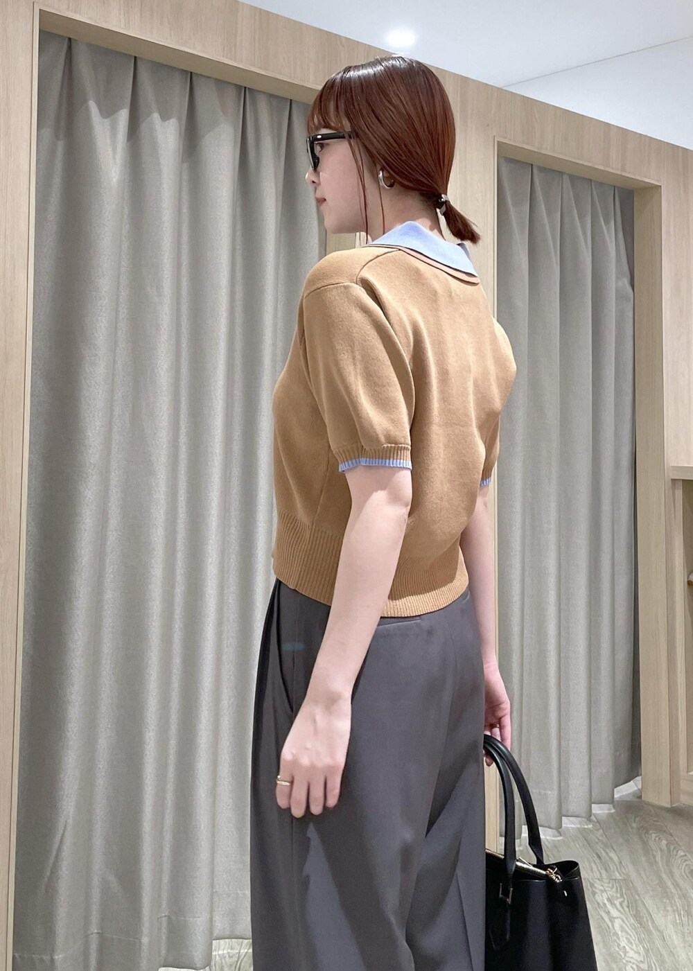 イエロー系のポロシャツ、ブラック系のトートバッグ、グレー系のその他パンツを着用したレディースの春コーディネートの6枚目の写真