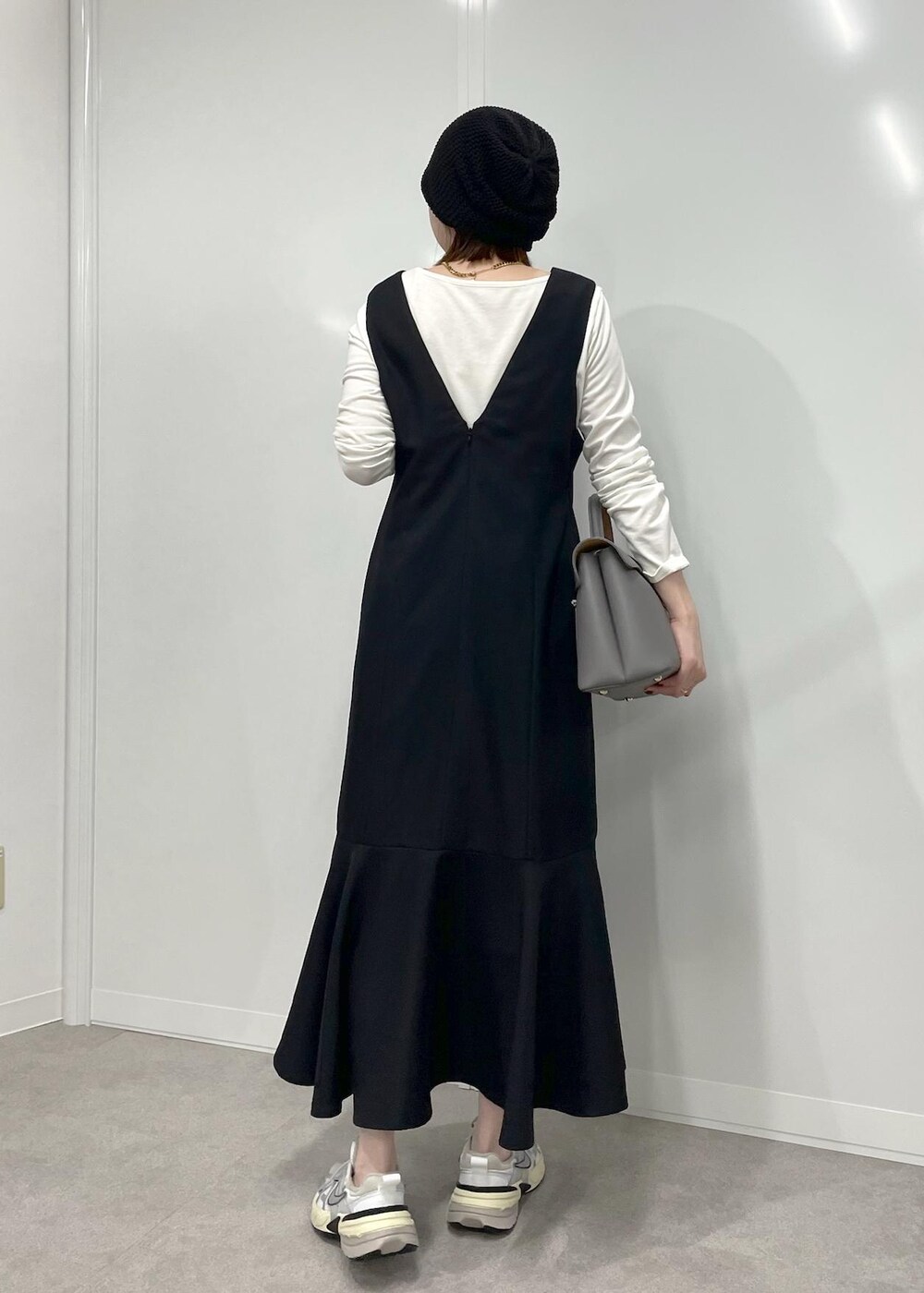 グレー系のハンドバッグ、ブラック系のワンピース、ホワイト系のTシャツ/カットソーを着用したレディースの冬コーディネートの7枚目の写真