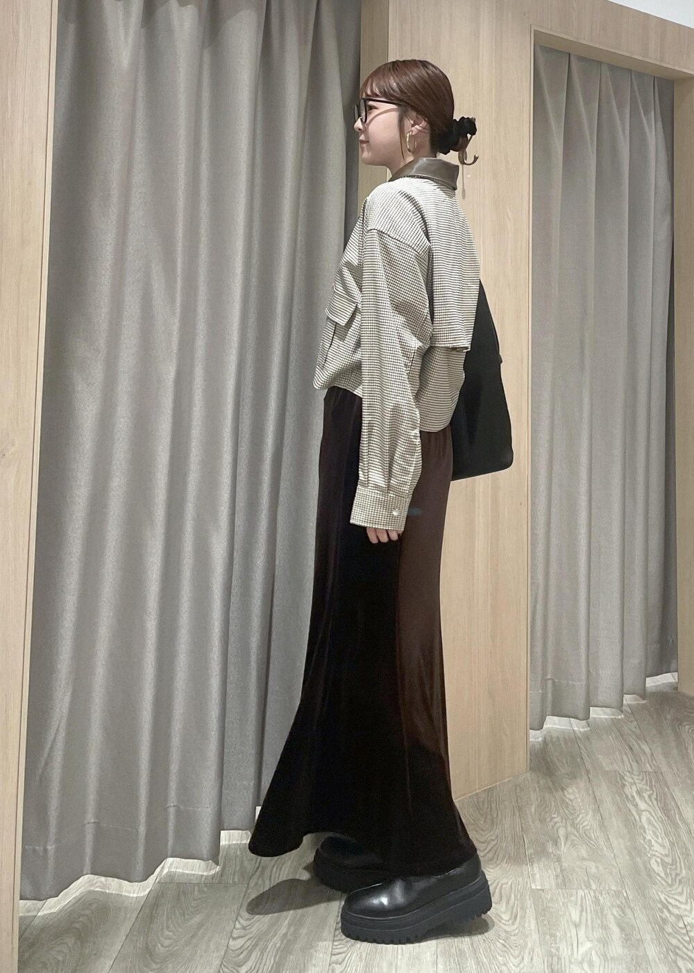 ブラック系のショルダーバッグ、ブラック系のブーツ、ベージュ系のカバーオールを着用したレディースの秋コーディネートの2枚目の写真