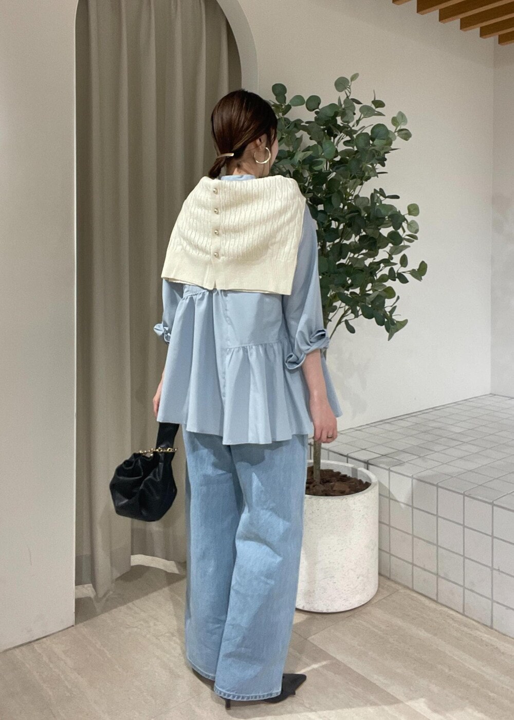 ブラック系のパンプス、ブルー系のシャツ/ブラウス、ホワイト系のカーディガン/ボレロを着用したレディースの冬コーディネートの3枚目の写真