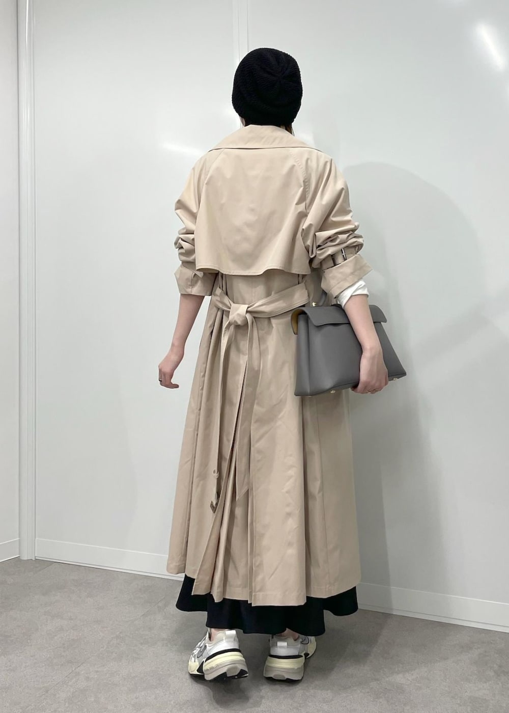 グレー系のハンドバッグ、ブラック系のワンピース、ホワイト系のTシャツ/カットソーを着用したレディースの冬コーディネートの3枚目の写真