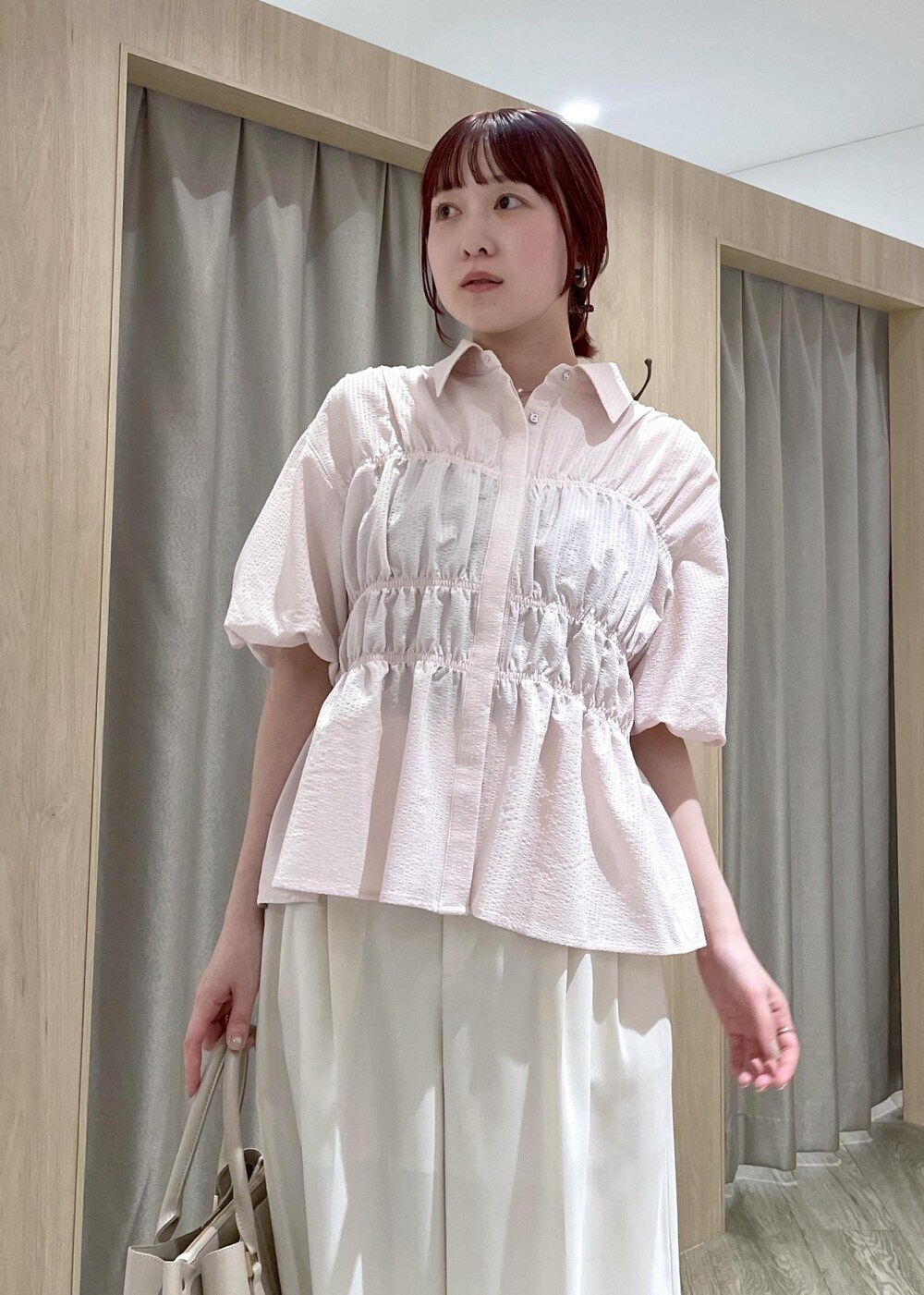 ベージュ系のトートバッグ、ブラウン系のパンプス、ホワイト系のその他パンツを着用したレディースの春コーディネートの6枚目の写真